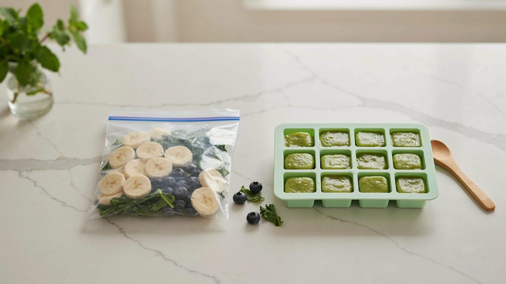 Freezer bags vs silicone trays filled with frozen smoothie ingredients on a kitchen counter