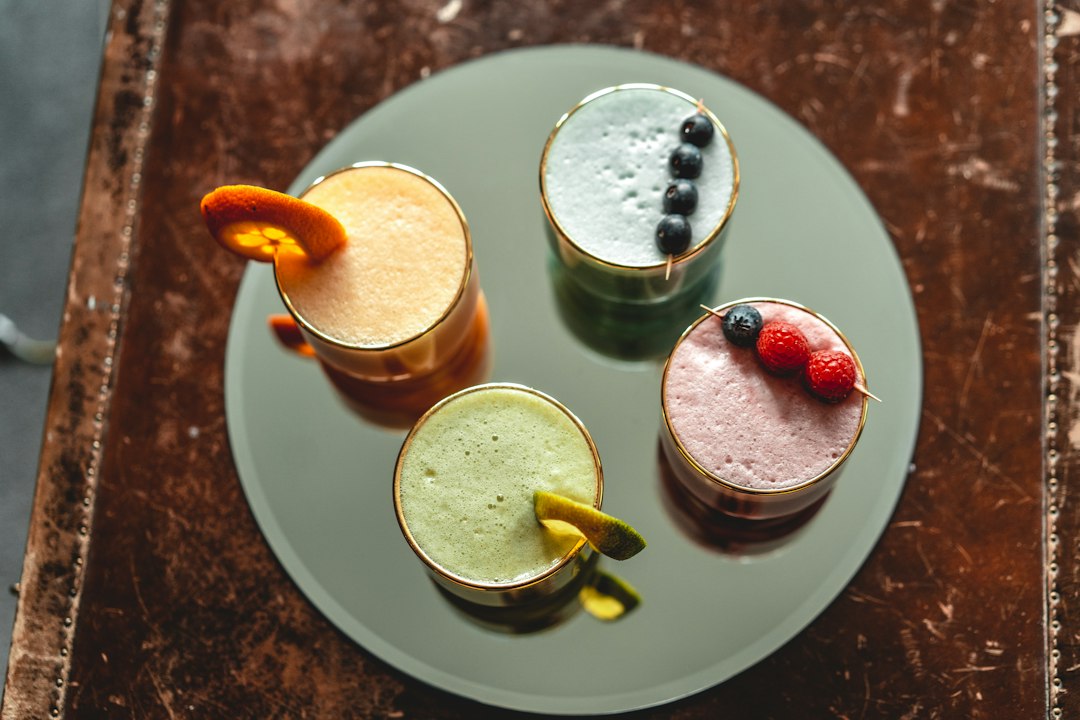 How to Make a Keto Smoothie Without Protein Powder Using Whole Foods 2 Three colorful keto smoothies without protein powder in short glasses showcasing different flavors.