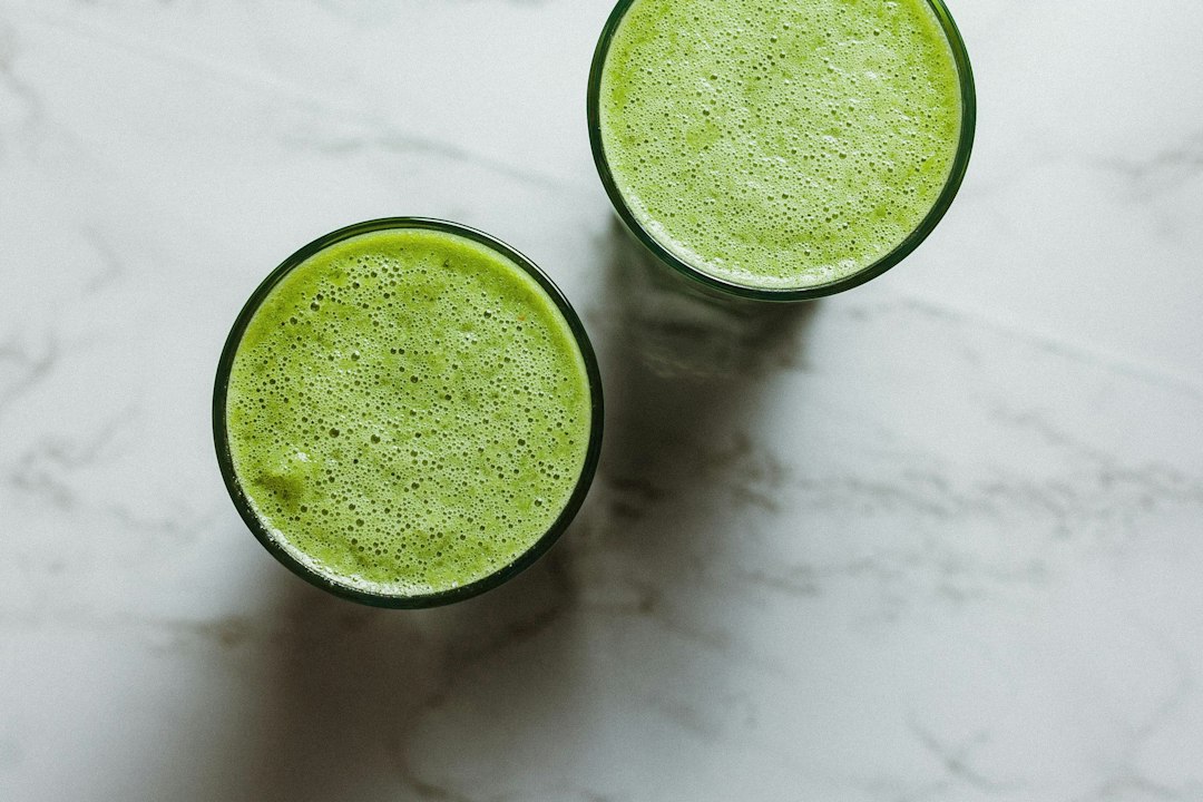 How to Make a Keto Smoothie Without Protein Powder Using Whole Foods 1 A thick avocado and green spinach keto smoothie without protein powder served in a glass garnished with hemp hearts.